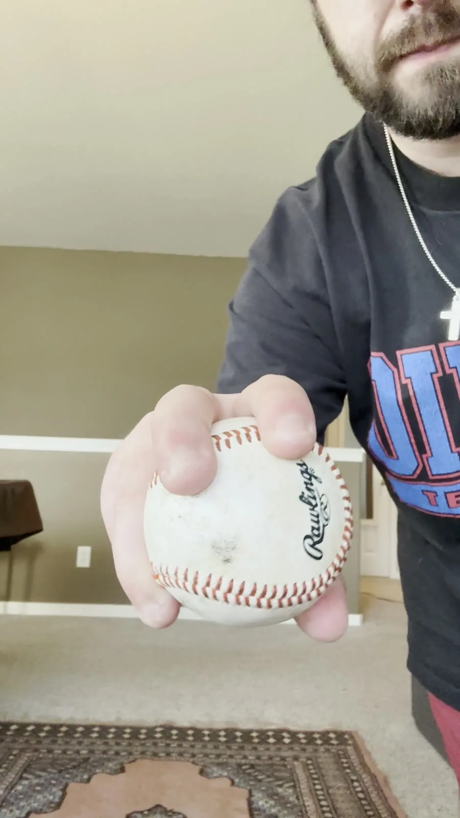 A looping close-up of Austin's four-seam grip: two fingertips laid across the seam, the ball held out toward the camera.